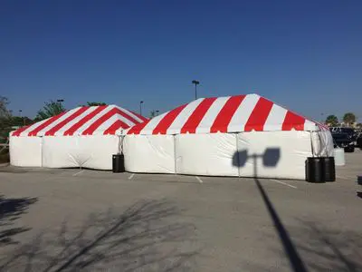Two large event tents on pavement.