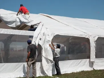 Team assembling a white event tent