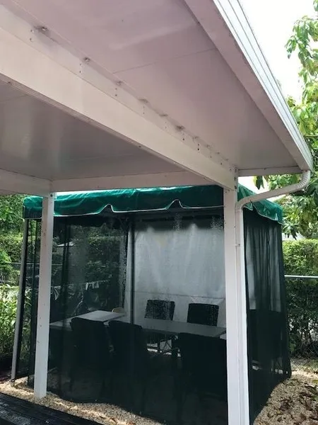 Green-roofed gazebo with chairs