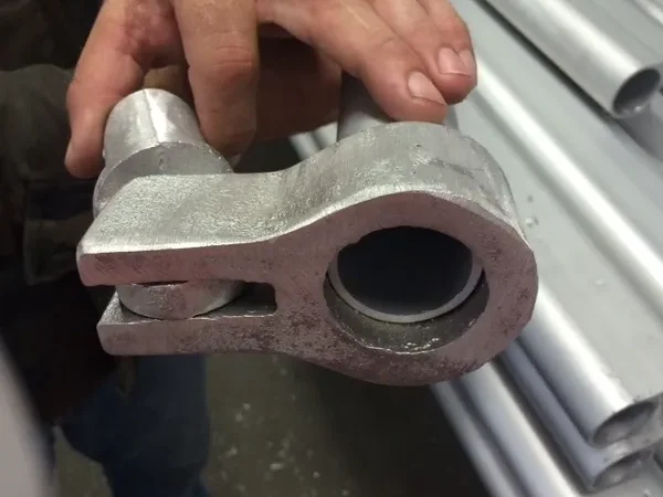 Hand holding a metal pipe fitting
