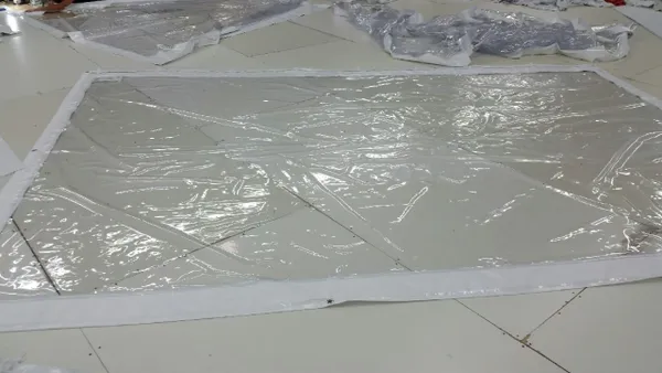 Plastic-wrapped glass panels on floor