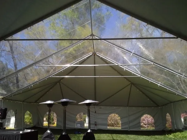 Transparent gabled tent overlooking leafy lawn
