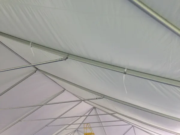 White tent ceiling with metal support beams.