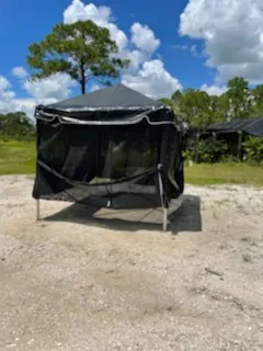Black canopy tent outdoors under blue sky