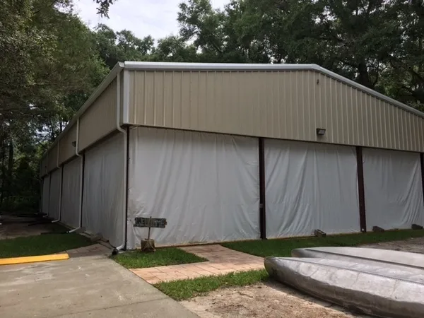 Large, covered storage structure near trees