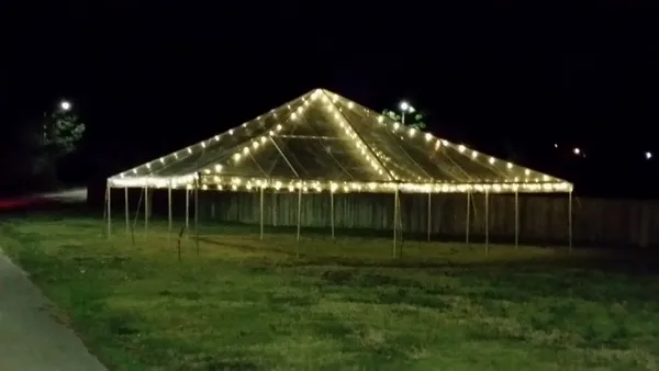 Illuminated tent on grass field