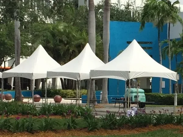 Three white tents near blue building