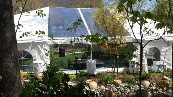 Outdoor event tent surrounded by greenery