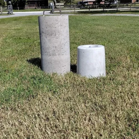 Concrete cylinders on grassy field