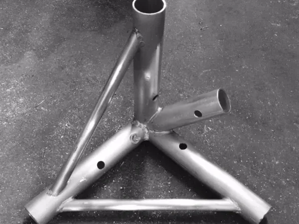 Angular metal tube base with welded braces