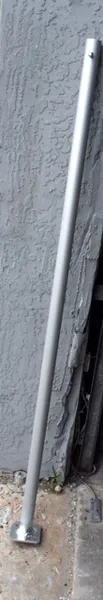 Long metal rod beside concrete wall