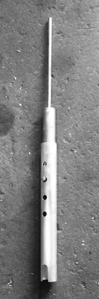 Industrial metal rod laying on concrete surface.