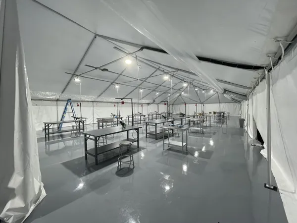 Large empty tent with tables and chairs.