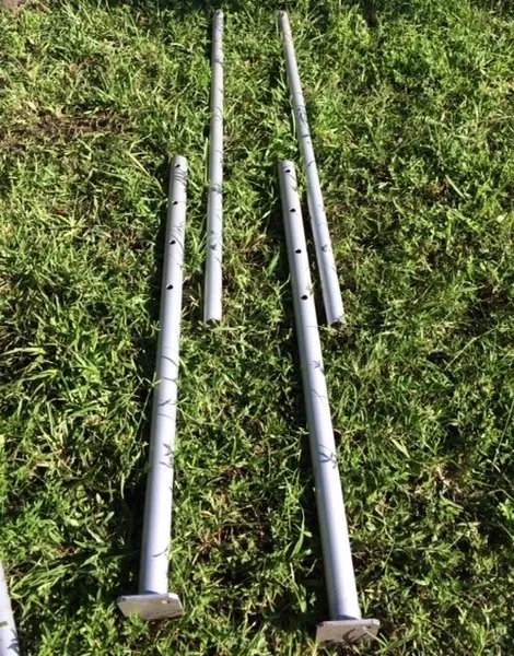 Steel tubes arranged on grassy field