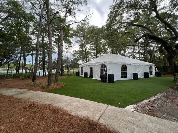 White event tent in wooded area