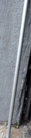 Metal pole leaning against textured wall