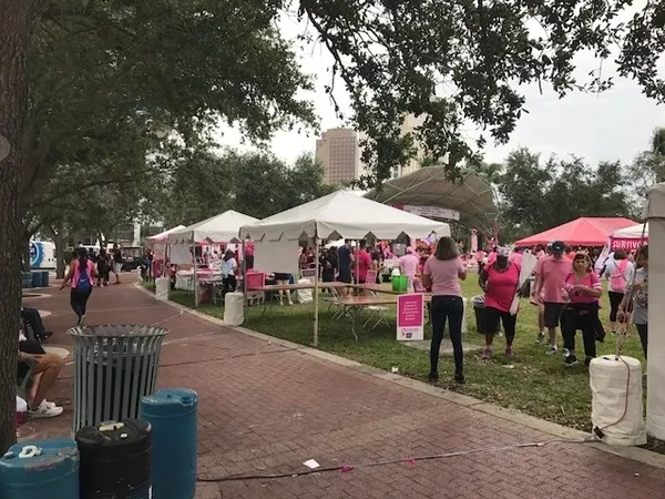 Outdoor event with pink tents and participants.